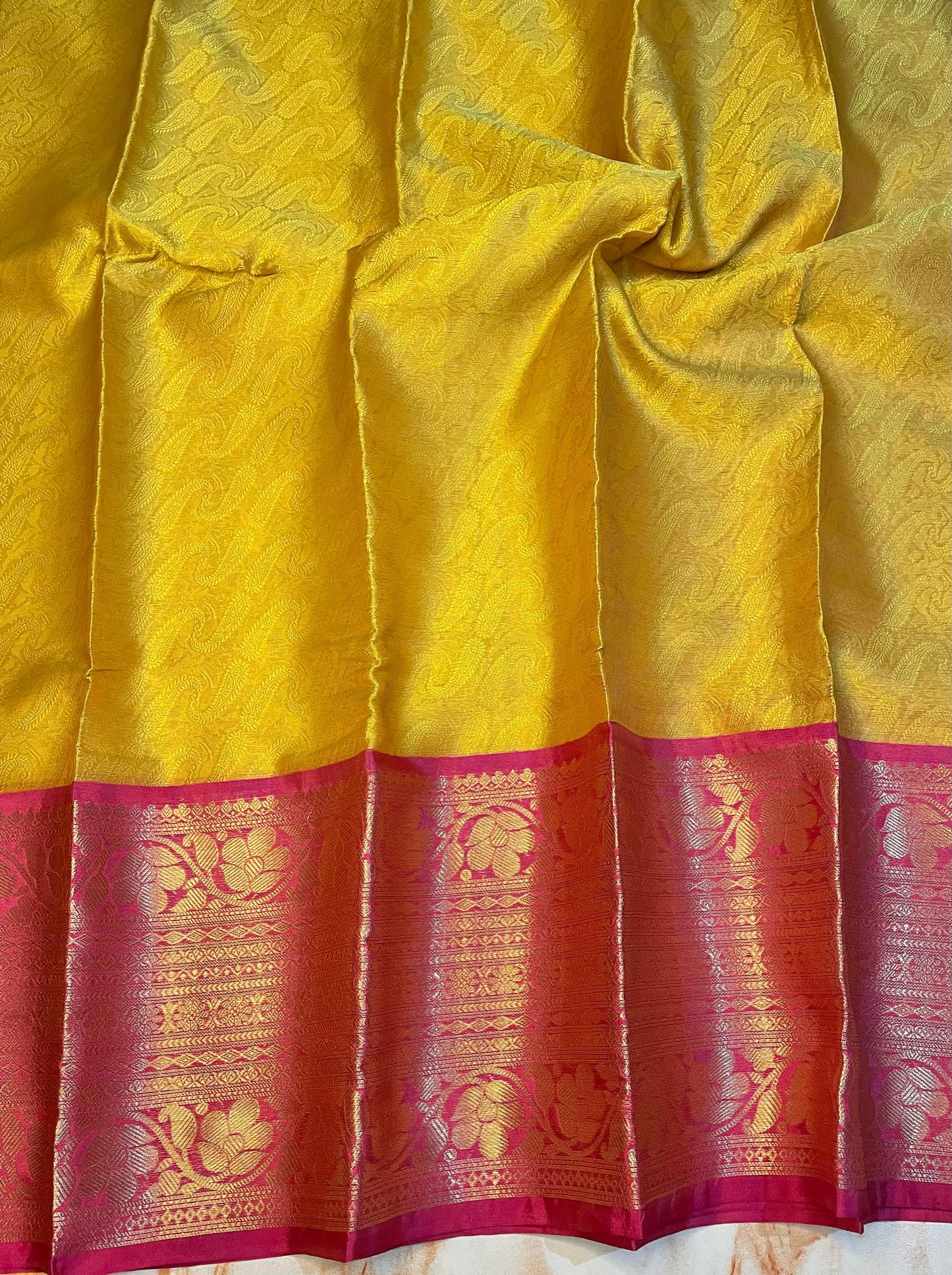 Attractive Kanjeevaram Gold saree with dark pink Zari weaving skirt border
