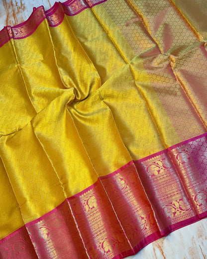 Attractive Kanjeevaram Gold saree with dark pink Zari weaving skirt border