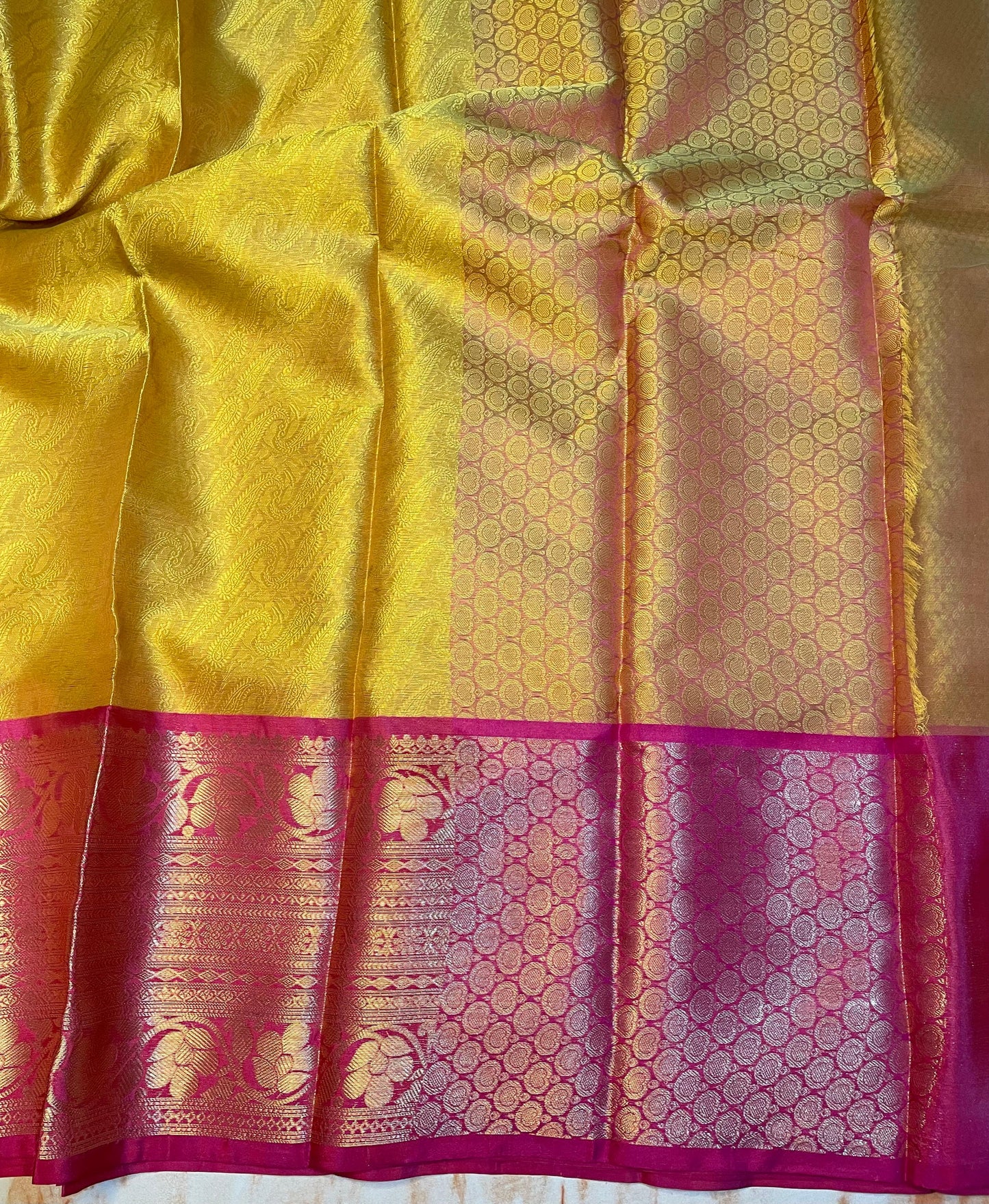 Attractive Kanjeevaram Gold saree with dark pink Zari weaving skirt border