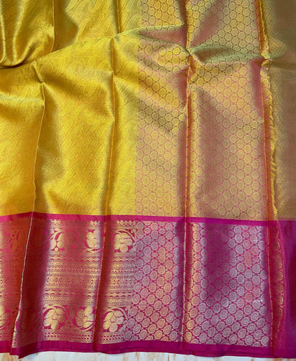 Attractive Kanjeevaram Gold saree with dark pink Zari weaving skirt border