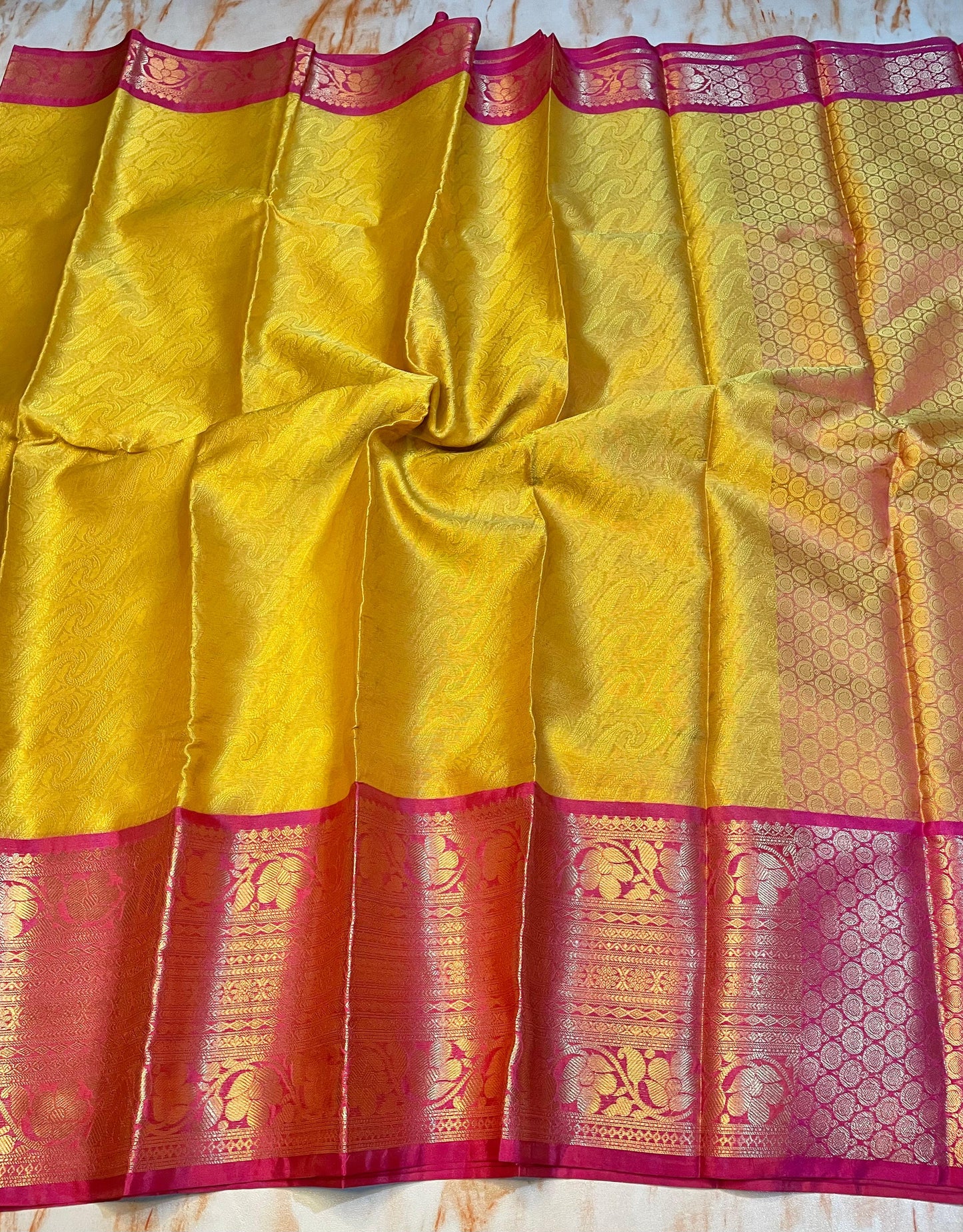 Attractive Kanjeevaram Gold saree with dark pink Zari weaving skirt border